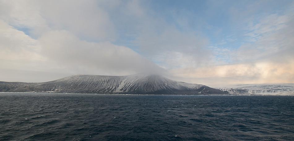 Saunders Island voraus, der 990 Meter über Meer liegende, noch aktive Vulkan Mount Michael liegt am frühen Morgen in den Wolken.