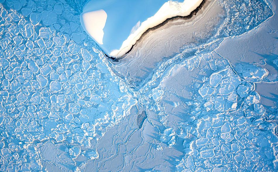 Ein Eisberg treibt im Weddellmeer durch Pfannkucheneis. So wird junges Eis genannt, das aufgrund der Wellenbewegung diese auffallend runde Form angenommen hat. Foto: IceCam / Stefan Hendricks, AWI