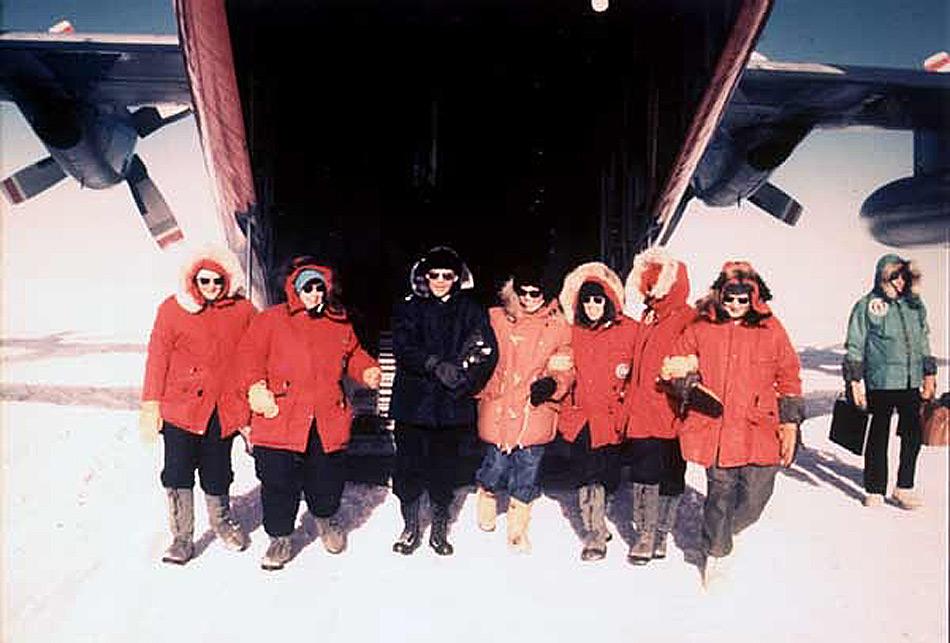 Die ersten Frauen, die ihre Füsse im November 1969 auf den Südpol setzen waren (von links nach rechts): Pamela Young, Lois Jones, Terry Tickhill, Eileen McSaveney, Kay Lindsay und Jean Pearson zusammen mit Konteradmiral D. F. Welch. Credit: Konteradmiral Kelly Welch, der diese offiziellen US Marine Bilder zur Verfügung stellte (www.southpolestation.com ).