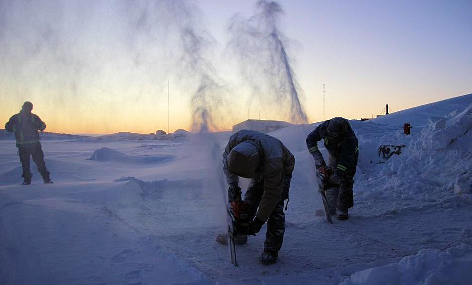 Das Stationspersonal benutzt Kettensägen, um Löcher in das Eis nahe der Station Mawson zu schneiden und so den Pool für den traditionellen „Midwinter Swim“ vorzubereiten. Bild: Shane Ness