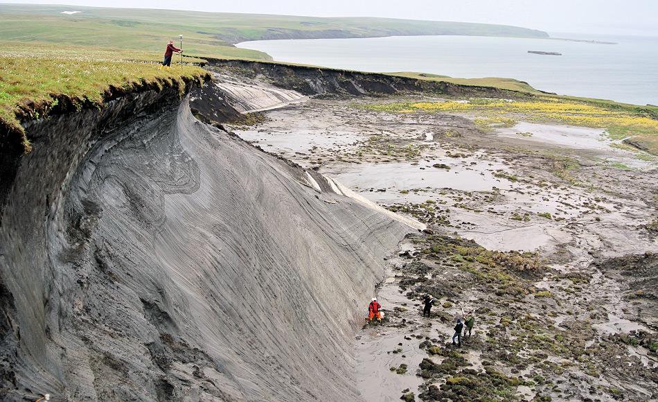 AWI-Permafrostforscherin Stefanie Weege erfasst die GPS-Koordinaten der erodierenden Steilküste auf der kanadischen Permafrost-Insel Herschel Island. Die Daten helfen der Wissenschaftlerin, das Ausmaß der Erosion zu bestimmen. Foto: Boris Radosavljevic