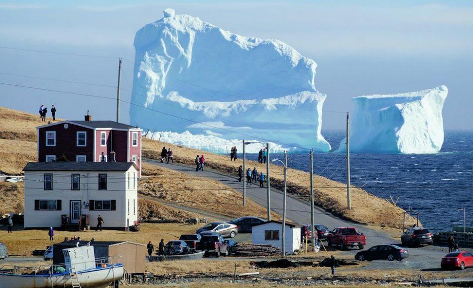 Die Kleinstadt Ferryland ist zu einem Touristenmagnet geworden aufgrund der Eisberge vor der neufundländischen Küste. Diese überragen die Häuser bei weitem. Bild: Reuters