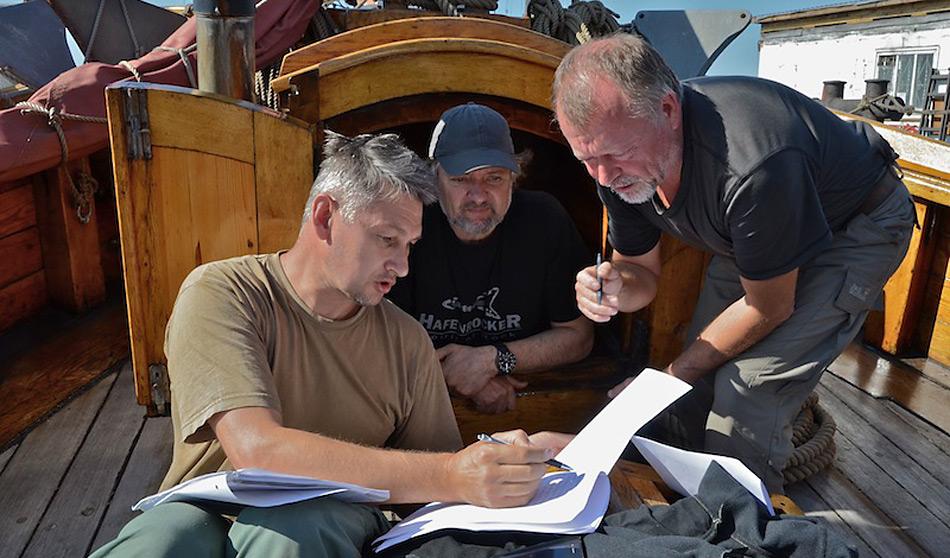 Arved Fuchs sitzt in Murmansk fest und berät mit Expeditionsteilnehmer über das weiter Vorgehen. V.l.n.r. Vladimir Melnik, Arved Fuchs, Vjatscheslaw Melin. Foto: Matthias Berg / AF Expeditionen